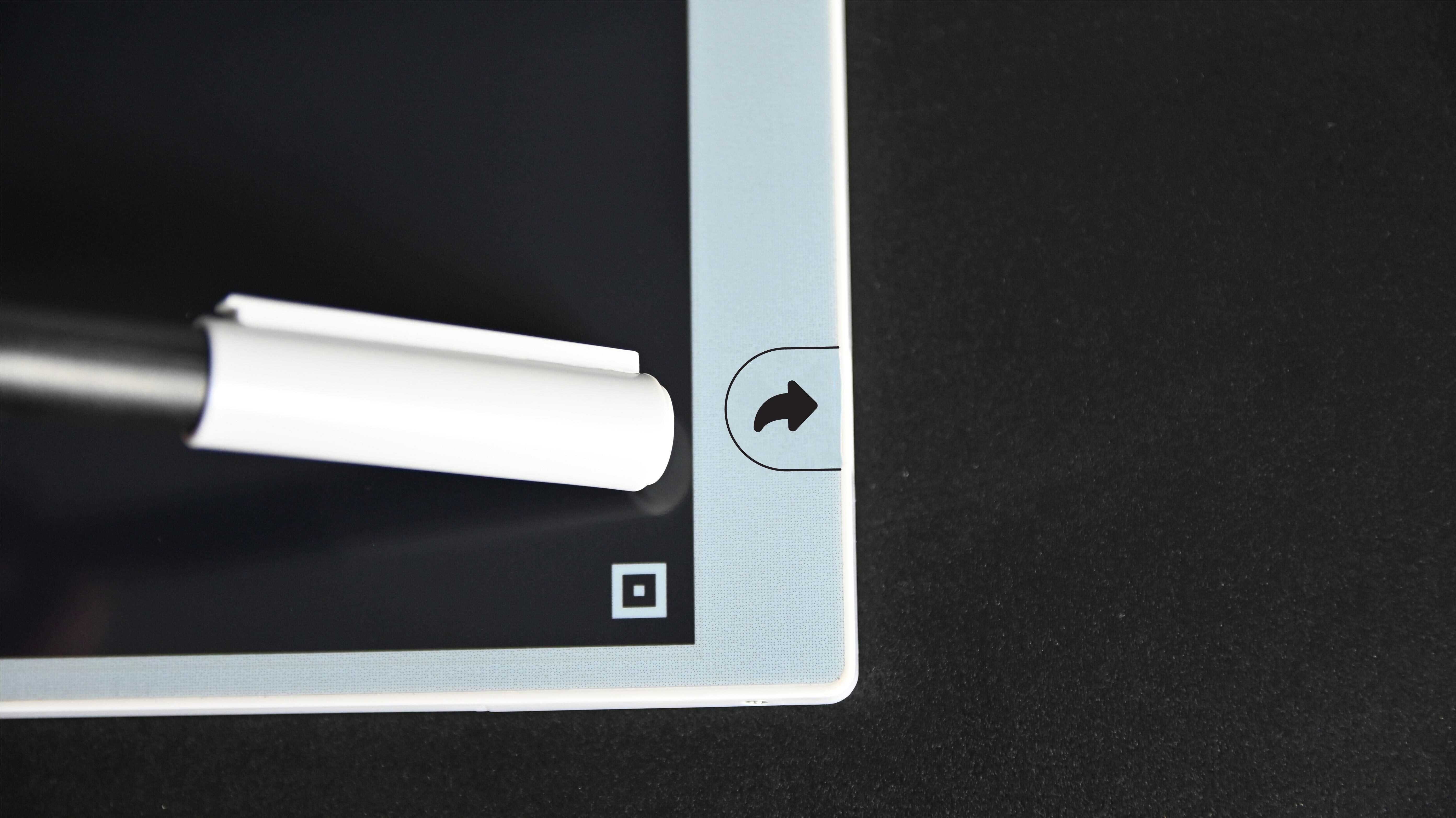 Close-up of a stylus on a digital tablet with a black background